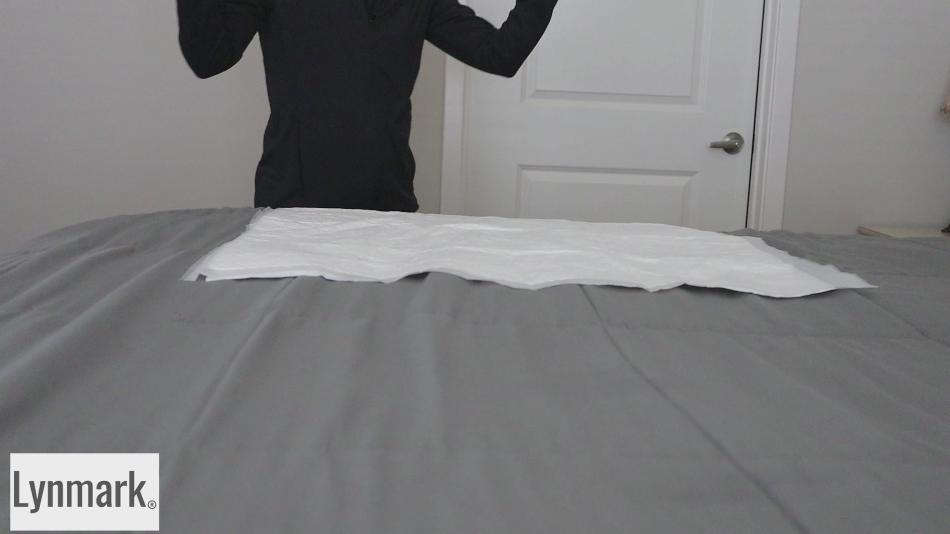 Video showing Lynmark white washable bed protector pad with tucks in use